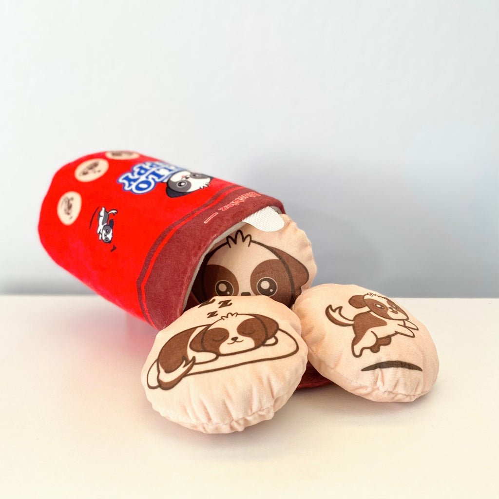 Red plush cylindrical dog toy with open end plus two beige round dog-face toys