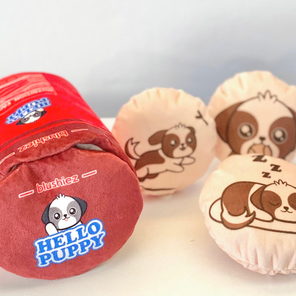 Close-up of red plush cylindrical dog toy and two beige round dog-face squeaky toys