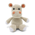 Crocheted hippo plush toy, cream with orange ears and paw accents, button eyes.