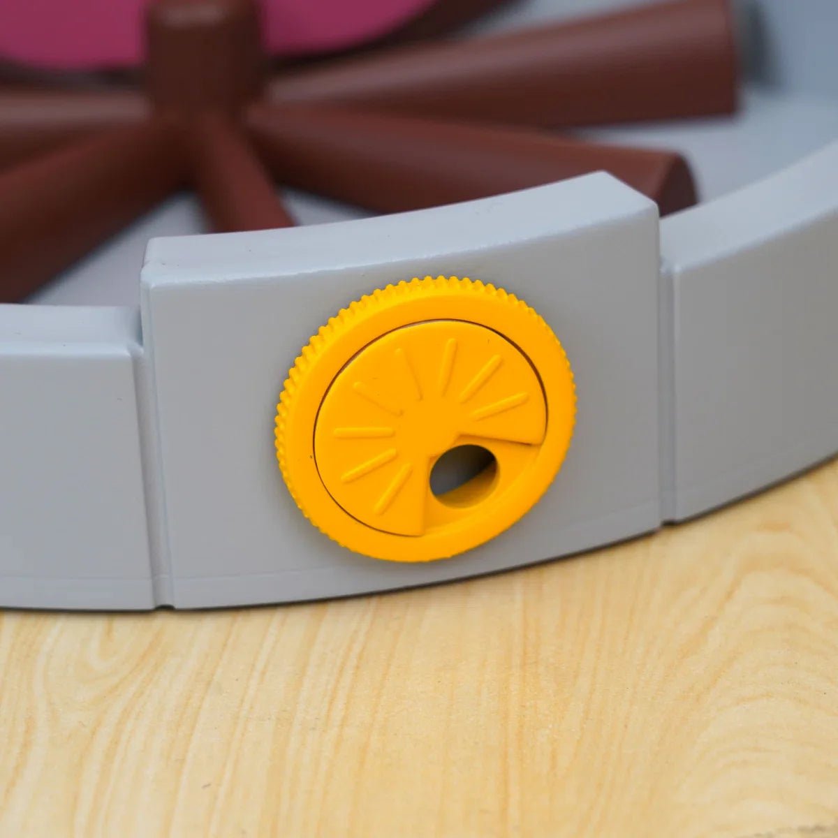 Gray base with yellow circular control dial and brown slotted feeder arms