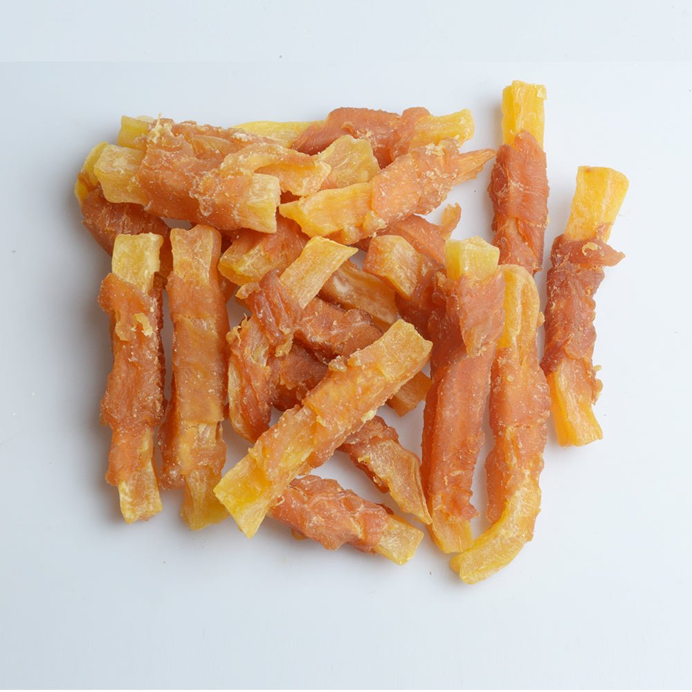Chicken and sweet potato dog treat strips, orange and yellow pieces in a small pile