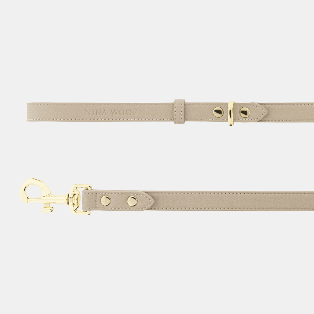 Beige vegan leather dog leash with gold-tone hardware and adjustable holes