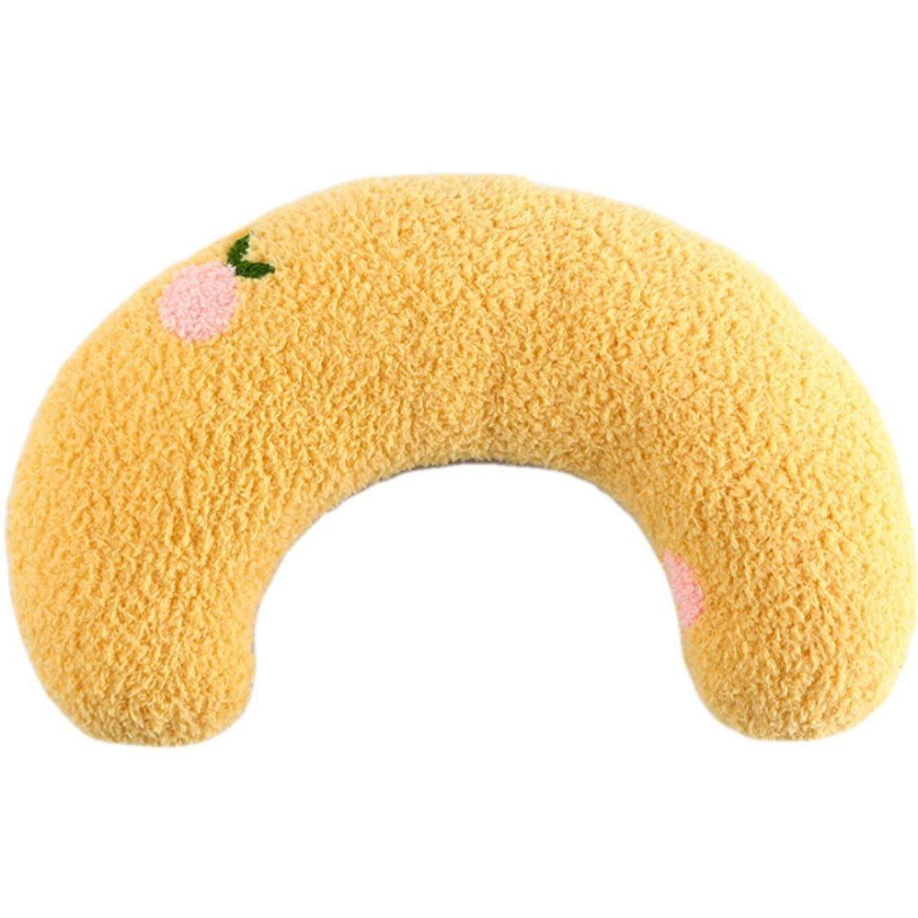 Yellow U-shaped neck protector pillow with pink flower accents and green leaves