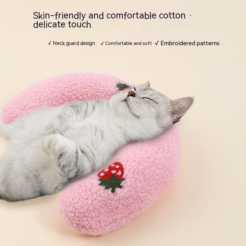 Pink U-shaped plush cat neck pillow with strawberry applique, white cat sleeping