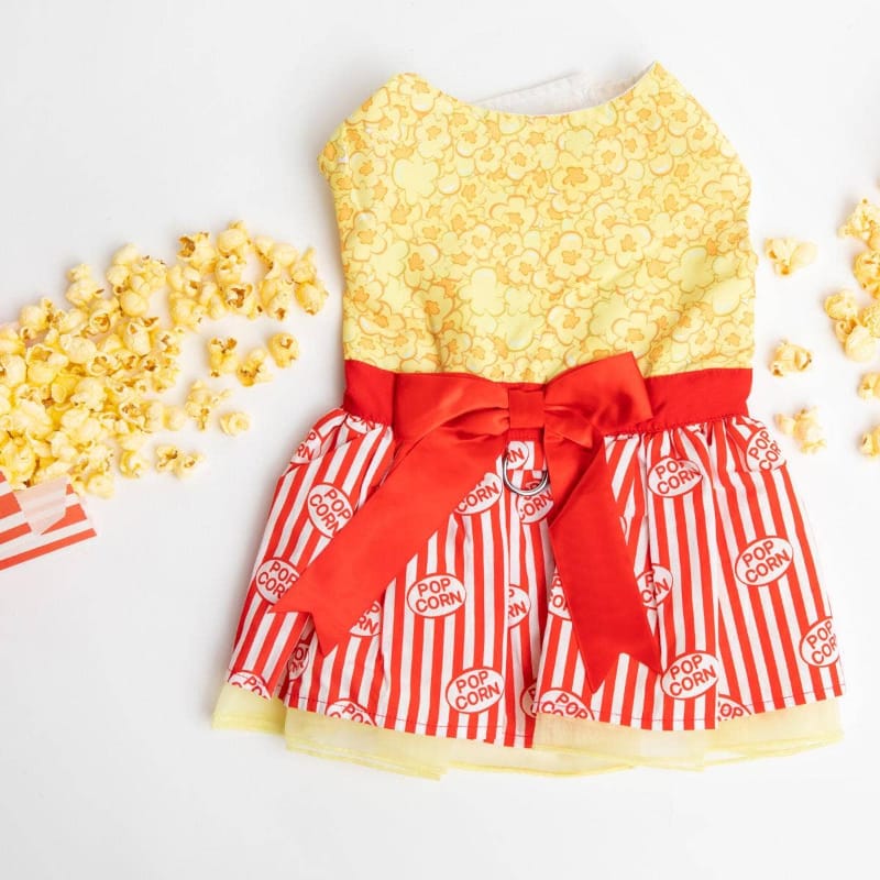 Yellow popcorn-pattern dog dress with red bow sash and red-and-white striped skirt