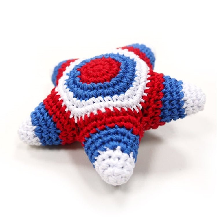 Crocheted star toy side view with red and blue stripes and white-edged red emblem