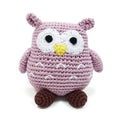 Crochet owl toy in mauve with white face, yellow beak, black eyes, and brown feet