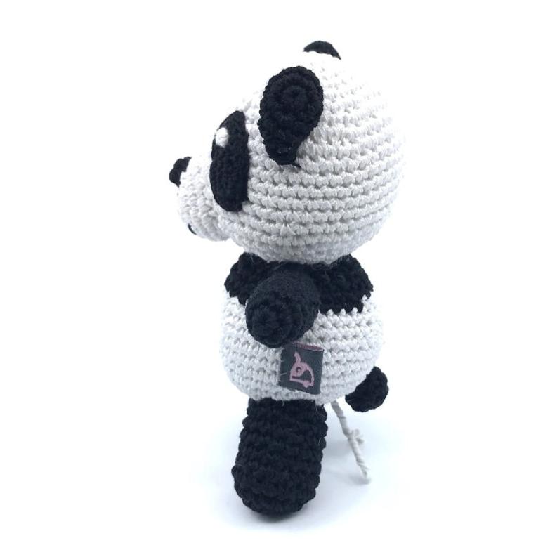 Crochet panda toy side view, black ears and bow tie, stitched belly label visible.