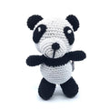 Crochet panda toy with white body, black ears and limbs, stitched smile and snout.