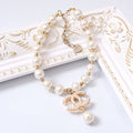 Pearl charm dog necklace with gold links, round pearl beads, and dangling angel charm