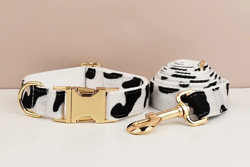 Black-and-white cow print dog collar with bow and matching leash with gold hardware