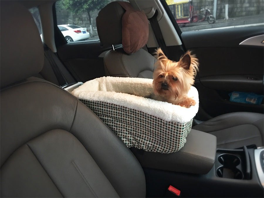 Plaid pet car bed with white sherpa top and black side straps in car seat