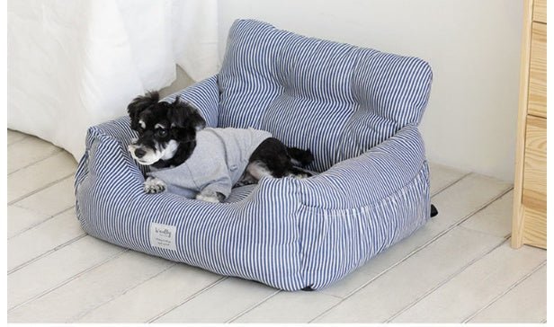 Blue and white striped pet bed cushion with raised bolsters and a small dog lying on it