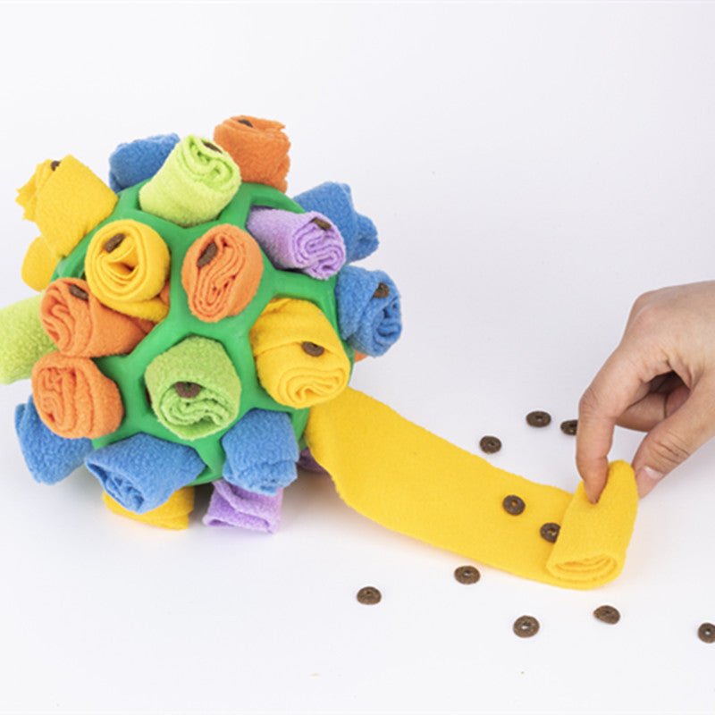 Multicolor fleece sniff toy ball with flat treat-filled handle and scattered brown bits