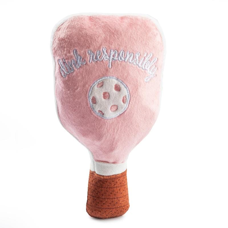 Plush dog toy pickleball paddle: pink plush face with circular ball graphic, green script, brown handle