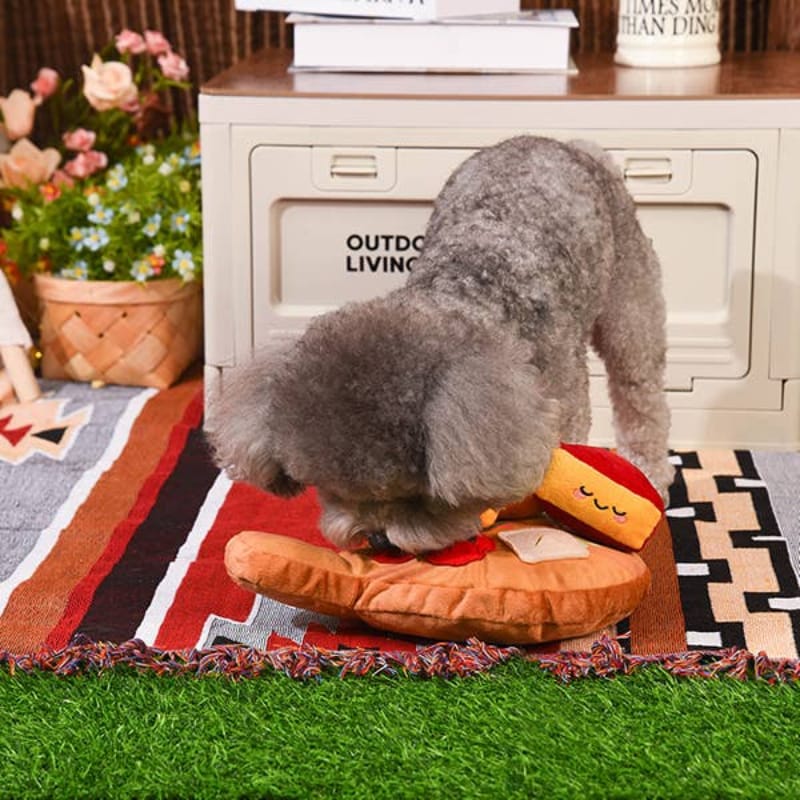 Plush cheese board toy with red and yellow pieces; gray dog sits on top