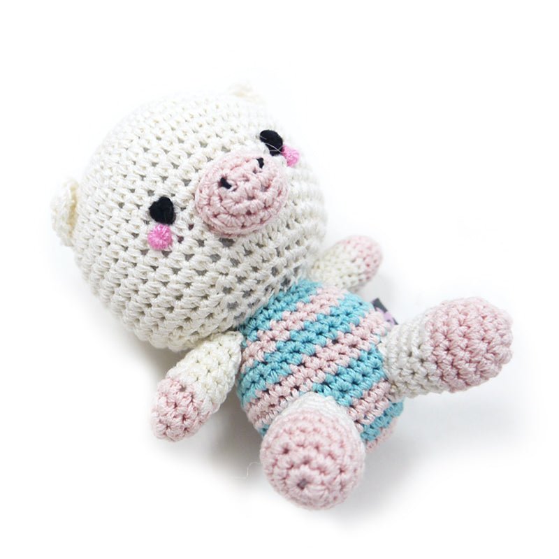 Crochet pig doll in side pose, cream body with pink snout and blue-pink striped outfit