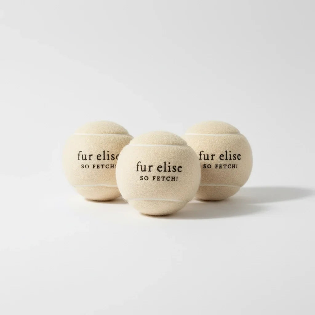 Three plush tennis balls, light beige, front ball centered with 'fur elise so fetch'