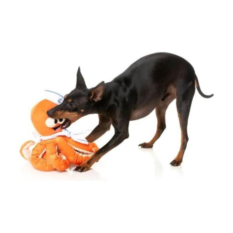 Orange octopus plush dog toy with white sailor cap and tentacles, held in mouth