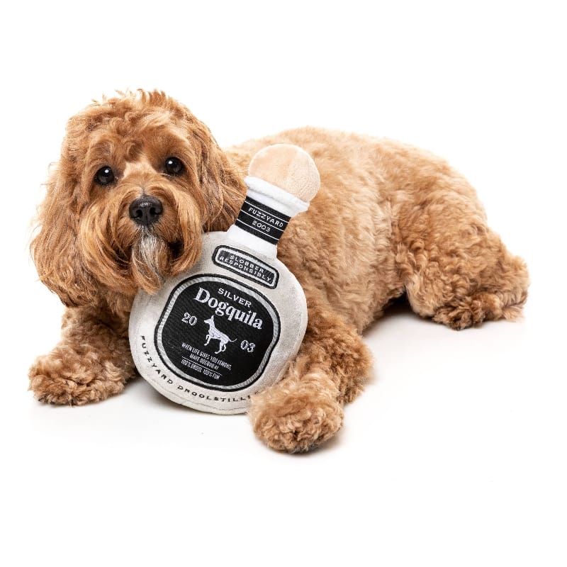 Tan bottle-shaped plush dog toy with squeaker and dark circular label