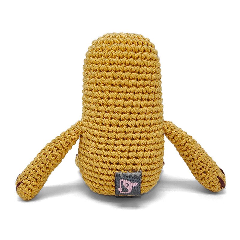 Crocheted sloth plush toy in mustard yellow with stitched fabric tag on belly