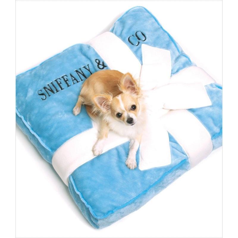 Sniffany pet bed blanket, light blue with white trim and bow; dog resting on it
