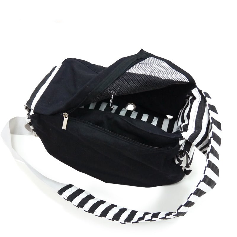 Dark sling bag with striped sides, open top, and mesh panel with zipper