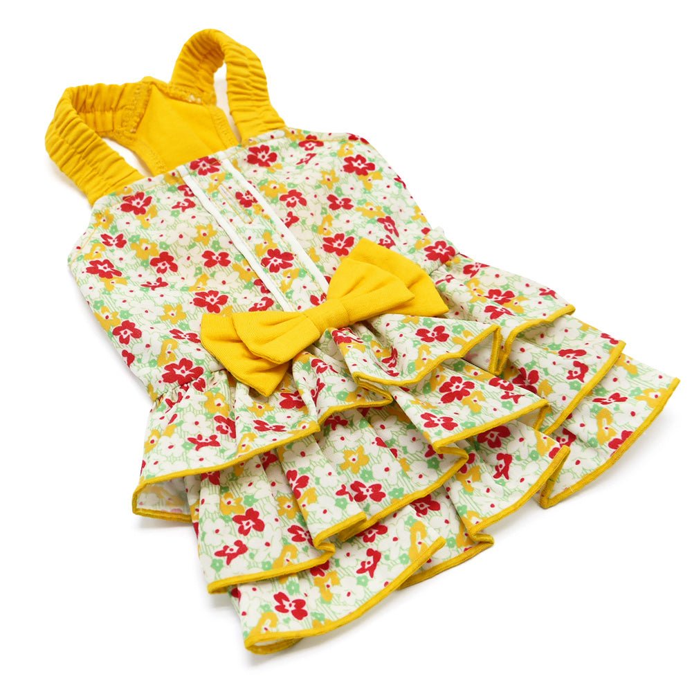 Dog dress laid flat: yellow top with floral tiered skirt and large matching bow.