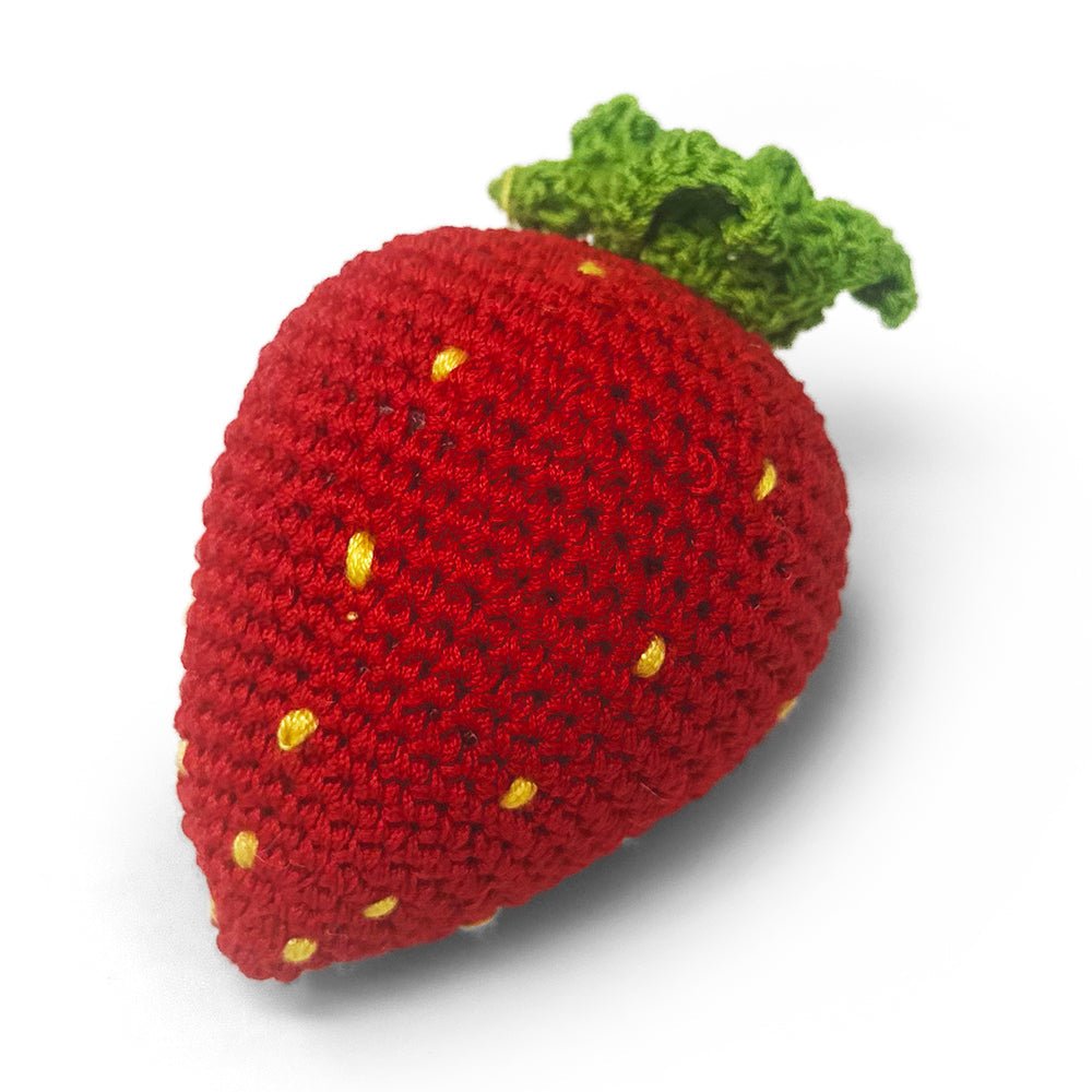 Crochet strawberry toy in red with green leafy top and yellow seed specks