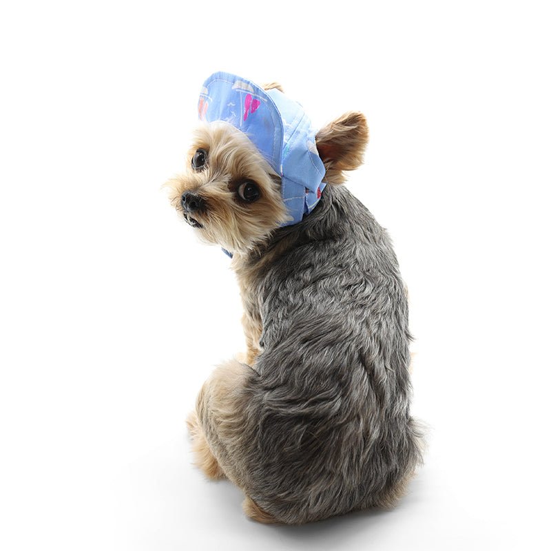 Blue beach hat with sailboat print, worn by small dog