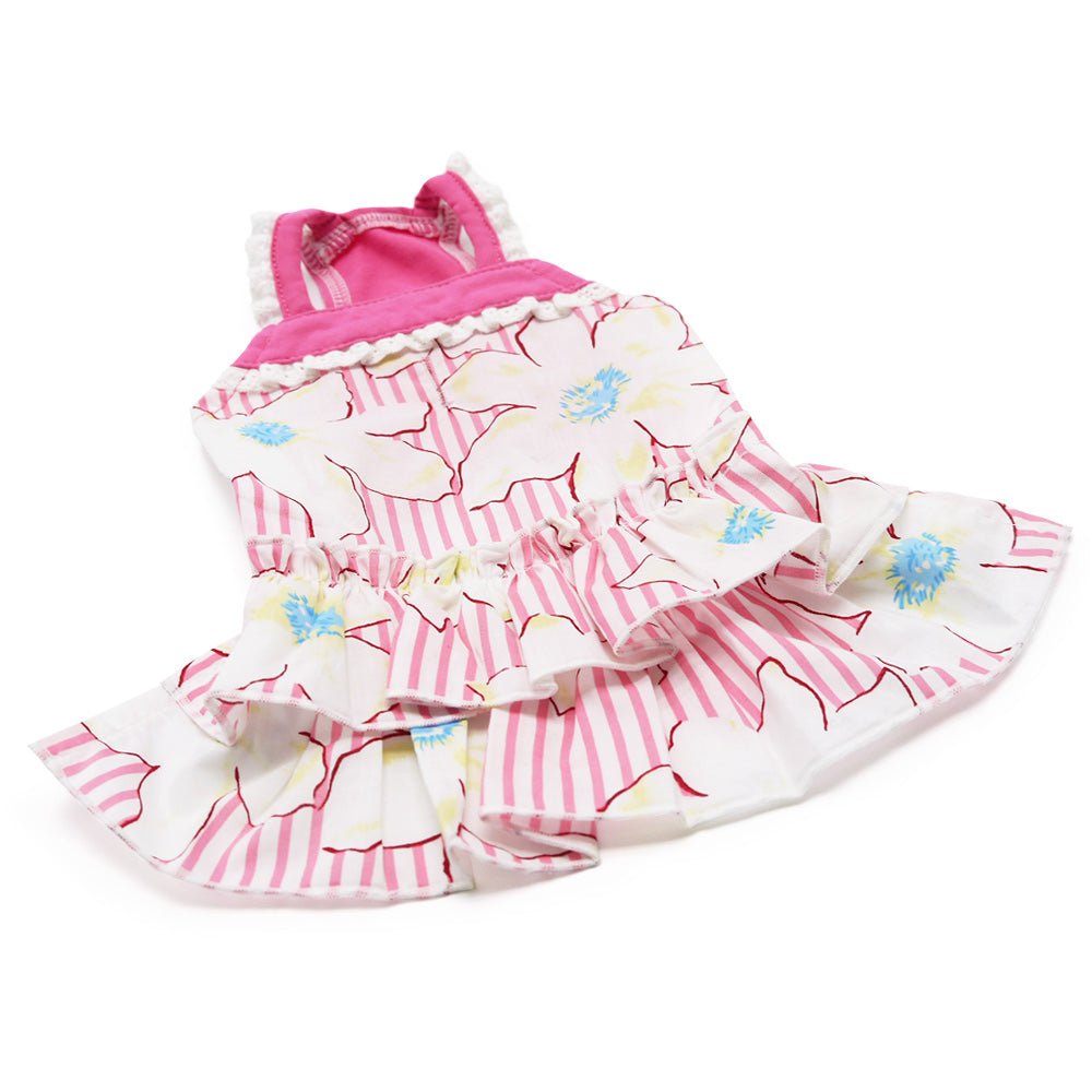 Pink and white pet dress laying flat, tiered ruffles, floral and stripe pattern.