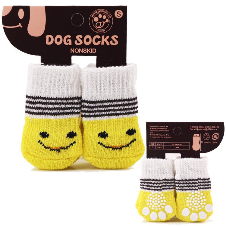 Yellow dog socks with white cuffs, gray stripes, and smiling faces; non-skid sole dots