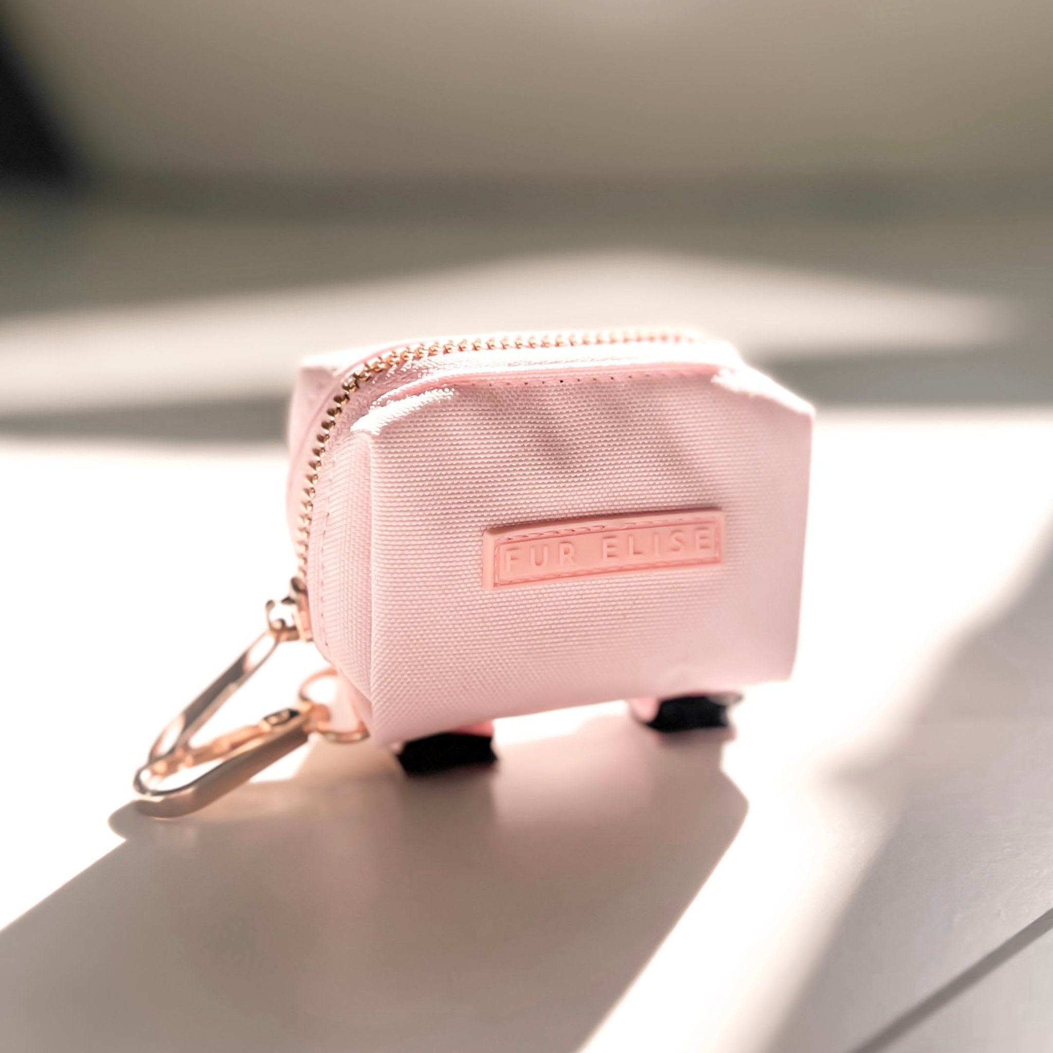 Pink zip pouch with gold carabiner clip and 'FUR ELiSE' label
