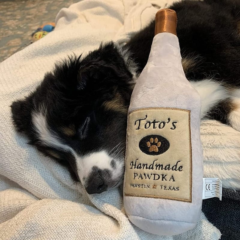 Cream Toto's Pawdka squeak plush bottle dog toy with brown cap and embroidered label