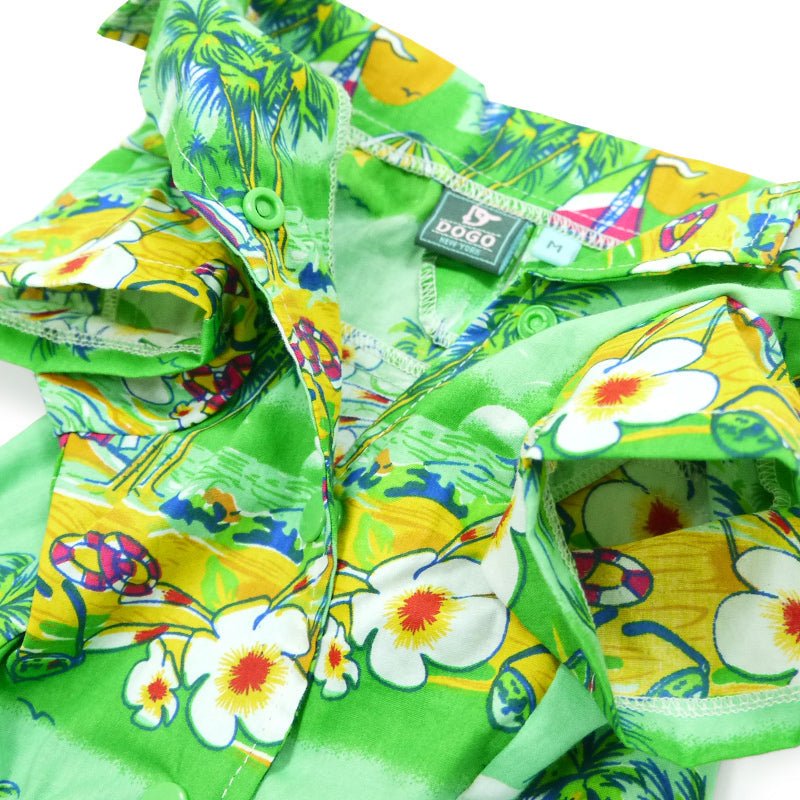 Close-up of green tropical dog shirt collar with snap buttons, tag, and island print