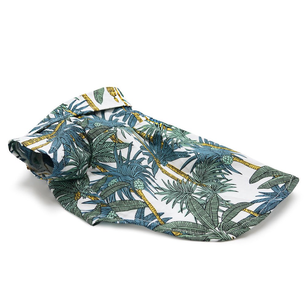 Tropical leaf pet shirt laid flat, blue and green print with yellow trim on white fabric
