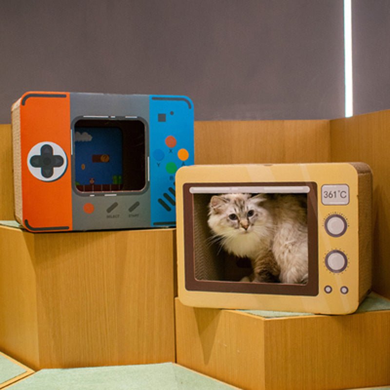 TV-shaped cat scratch house on shelf; light cat visible through rectangular window.