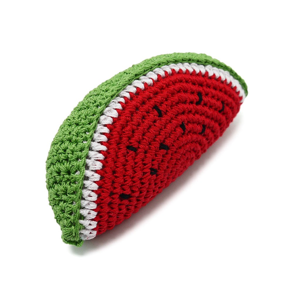 Crochet watermelon toy slice in red and green with white trim, side view