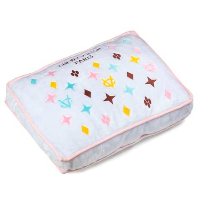 Chewy pet bed with light gray bolster, pink trim, and colorful star paw print on top
