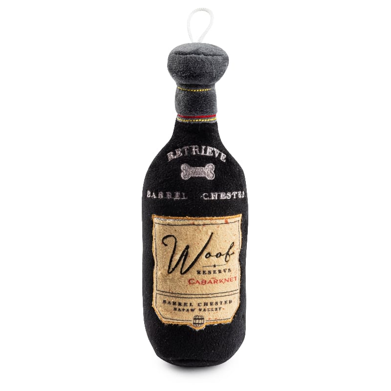 Black plush dog bottle toy with Woof Reserve Cabarknet label and hanging loop