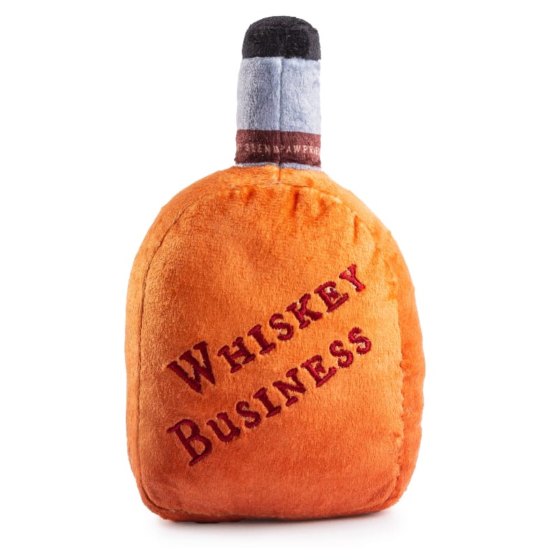 Plush squeaky dog toy bottle in orange with gray cap, “Whiskey Business” text