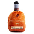 Plush squeaky dog toy bottle in orange with gray cap, front label and bone icon